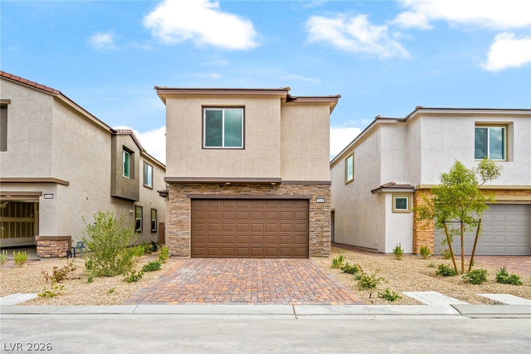 9568 Sagebrush Grove Street, Las Vegas, NV 89178 A stone-accented facade and paver driveway create a welcoming approach to this modern residence.