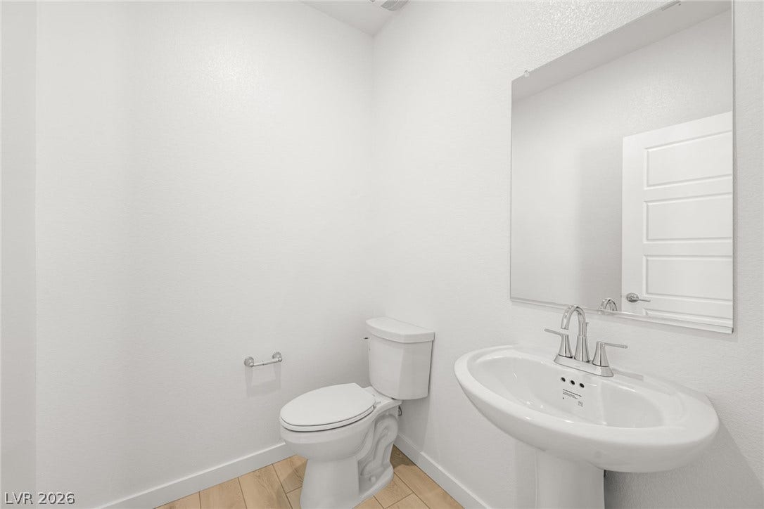 9568 Sagebrush Grove Street, Las Vegas, NV 89178 Clean lines and wood-look tile flooring define this modern powder room.