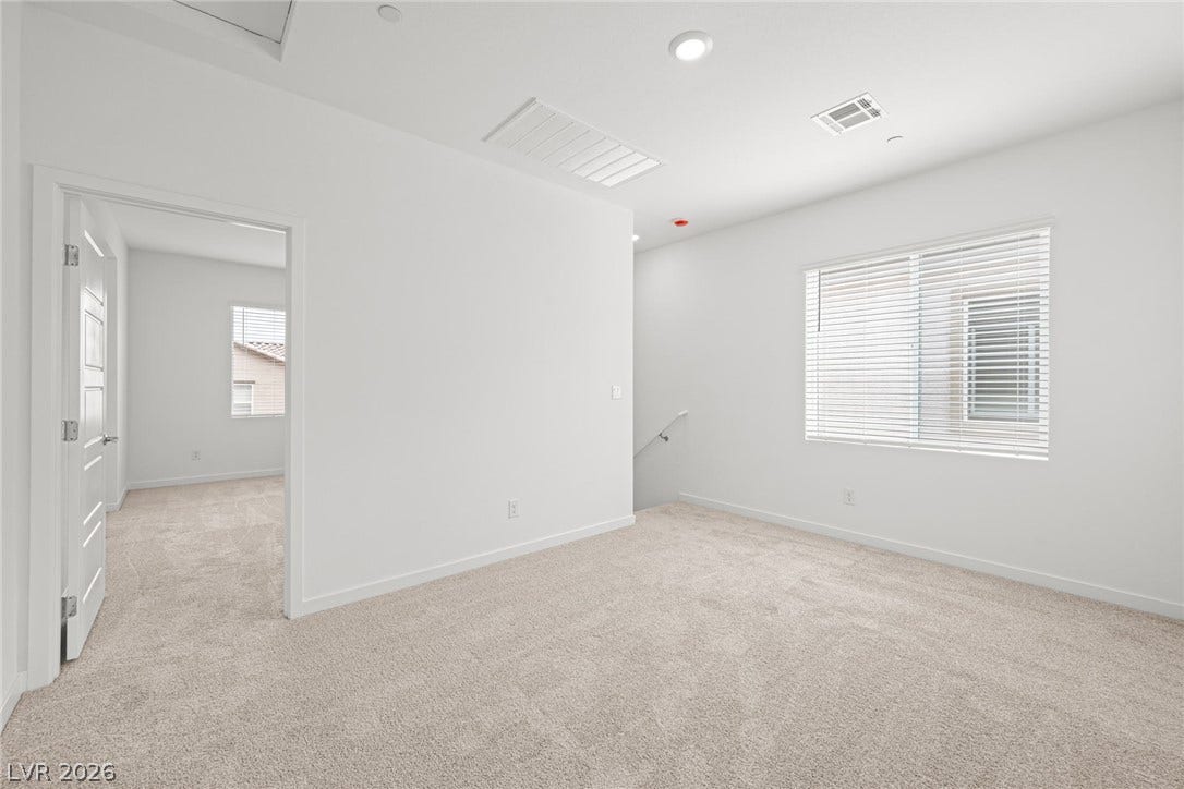 9568 Sagebrush Grove Street, Las Vegas, NV 89178 An open upstairs landing features soft carpeting and recessed lighting near the staircase.