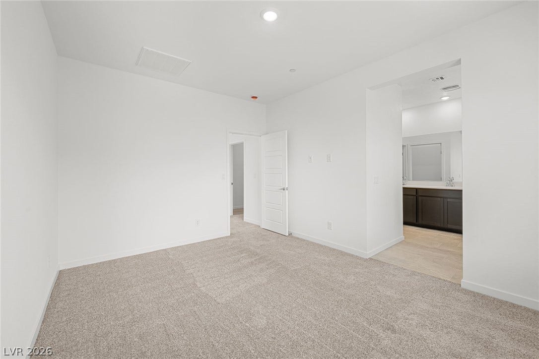 9568 Sagebrush Grove Street, Las Vegas, NV 89178 Plush carpeting and crisp white walls define this comfortable bedroom suite with an adjoining bath.