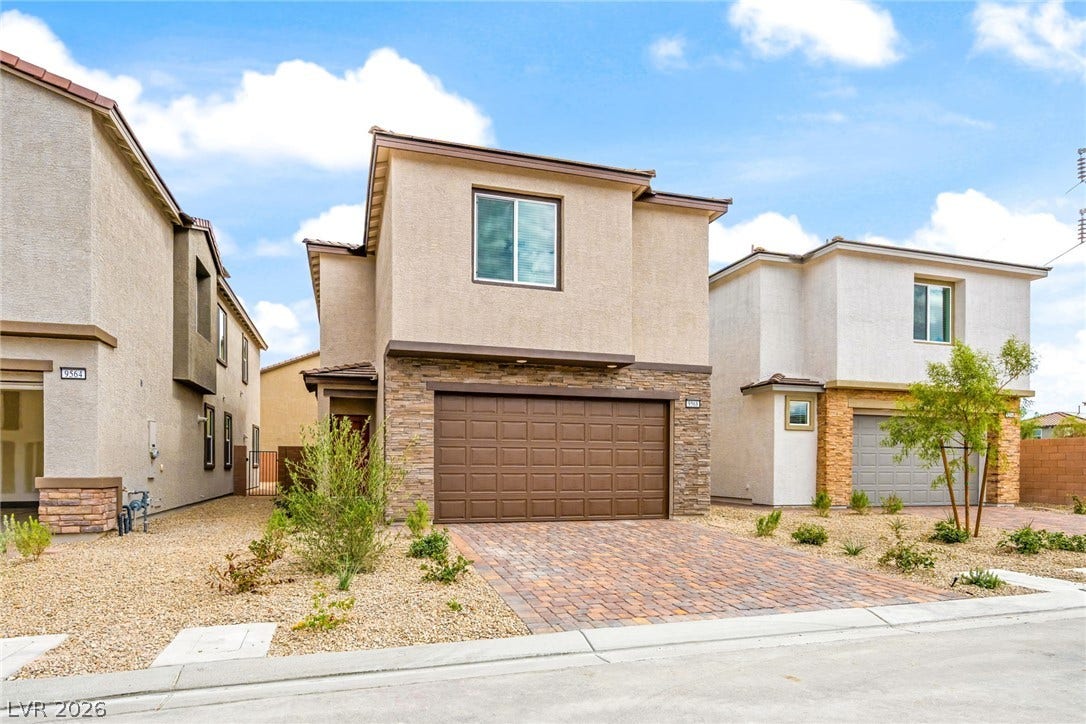 9568 Sagebrush Grove Street, Las Vegas, NV 89178 Modern multi-level architecture highlights this stucco exterior featuring stone veneer accents and a paved driveway.