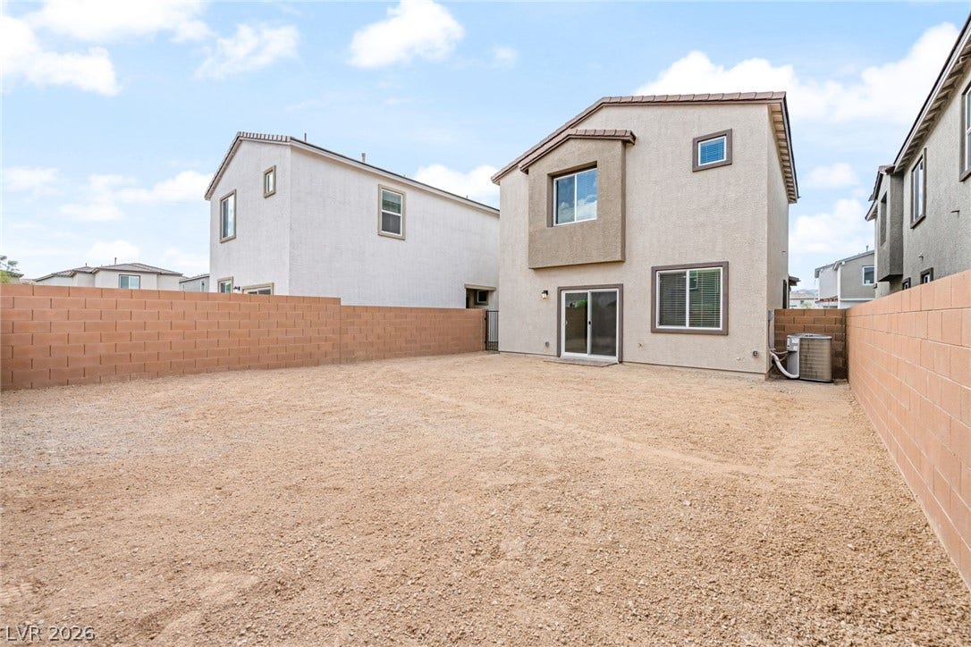 9568 Sagebrush Grove Street, Las Vegas, NV 89178 An enclosed block wall surrounds a spacious gravel backyard, offering potential for personalized landscaping.