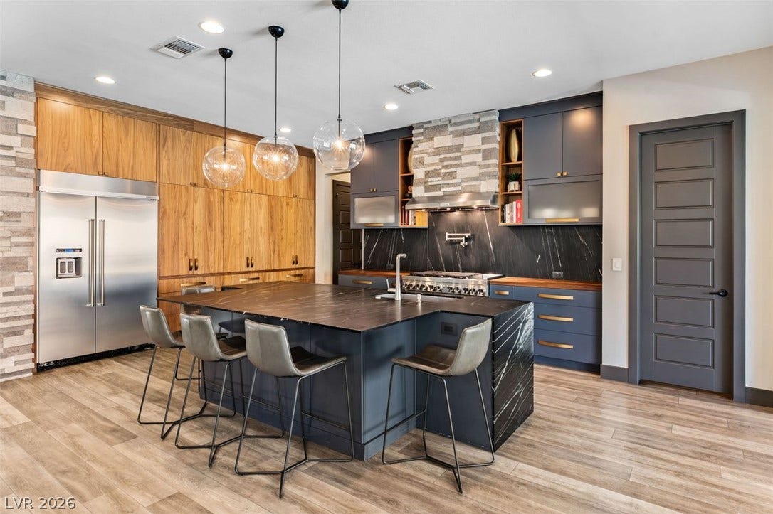 2999 The Peaks Lane, Las Vegas, NV 89138 newly renovated chefs kitchen with beautiful custom cabinetry to the ceiling. Ample storage and counterspace making it anyone's dream kitchen. Walnut cabinets feature pocket doors making it all useable space