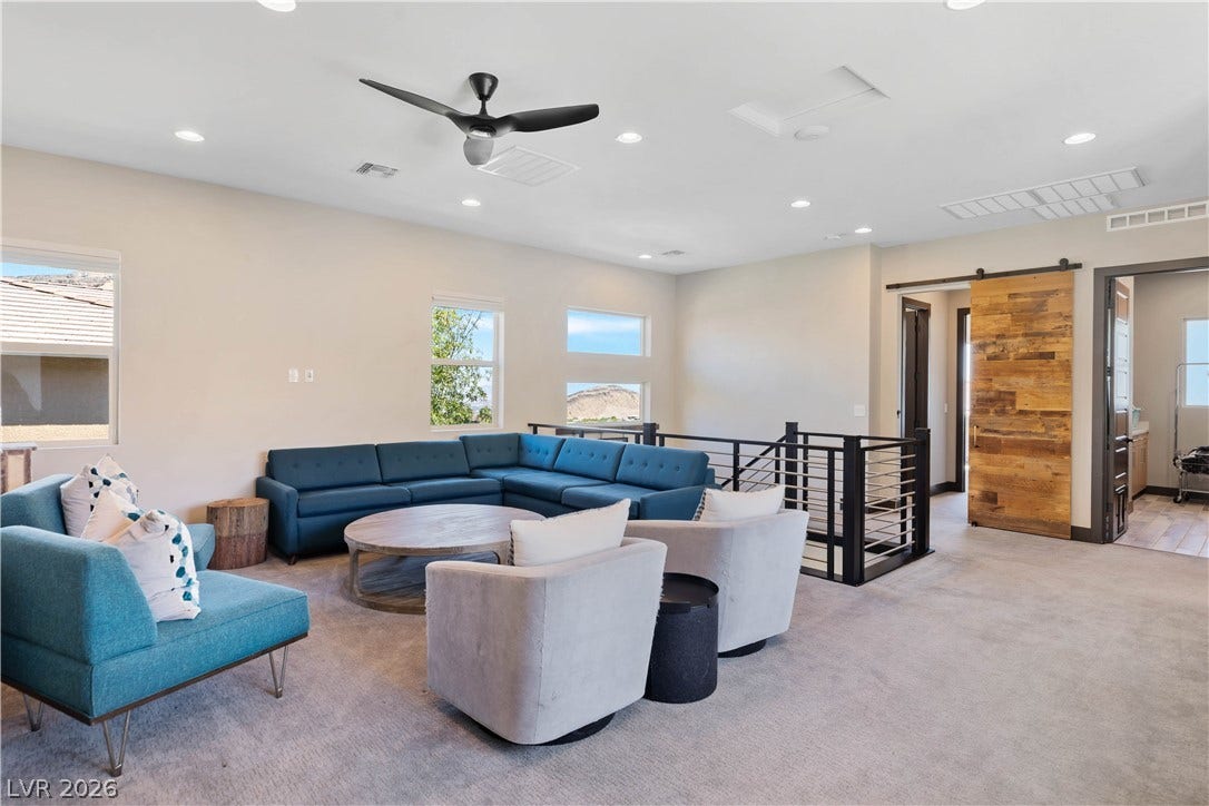 2999 The Peaks Lane, Las Vegas, NV 89138 An open upstairs loft features plush carpeting, recessed lighting, and a sliding barn door entry.