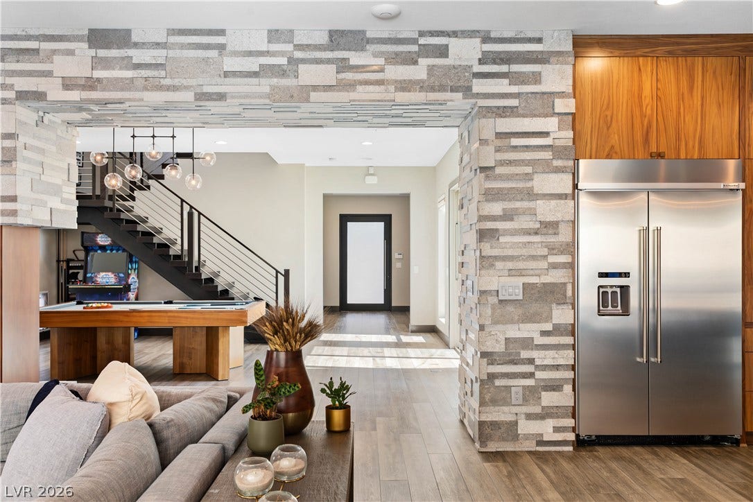 2999 The Peaks Lane, Las Vegas, NV 89138 An open floorplan seamlessly connects the living spaces under high ceilings with warm wood flooring.