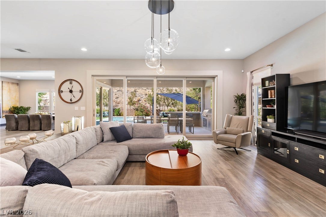 2999 The Peaks Lane, Las Vegas, NV 89138 A wall of upgraded sliding glass doors allowing lots of natural light. They open to connect the spacious great room and outdoor covered patio and outdoor kitchen