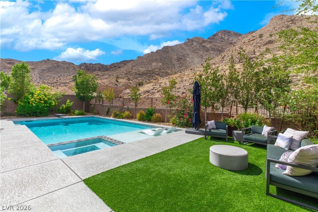 2999 The Peaks Lane, Las Vegas, NV 89138 Dramatic mountain backdrops frame a sparkling pool and spa surrounded by neat concrete decking.