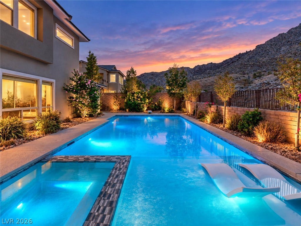 2999 The Peaks Lane, Las Vegas, NV 89138 Dramatic mountain backdrops frame a sparkling pool and spa set against a sunset sky.