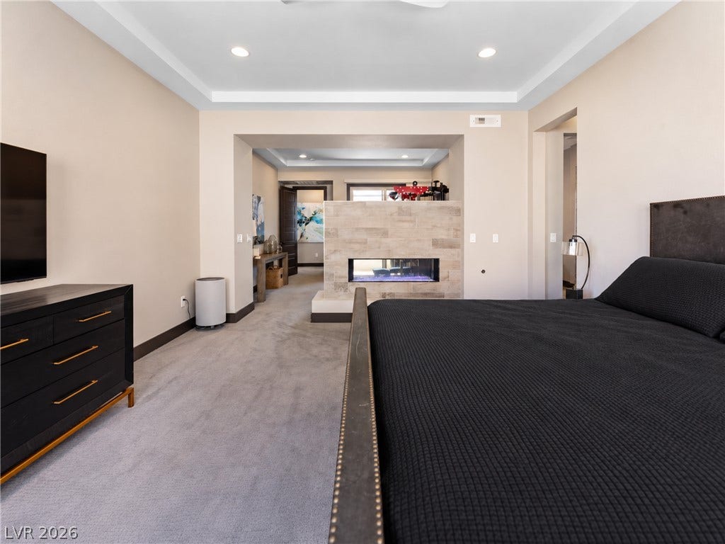 2999 The Peaks Lane, Las Vegas, NV 89138 Upstairs Primary bedroom (5) with large sitting area/gym separated by beautiful double sided fireplace. Huge Custom walk-in closet and highly upgraded primary bathroom and private balcony.