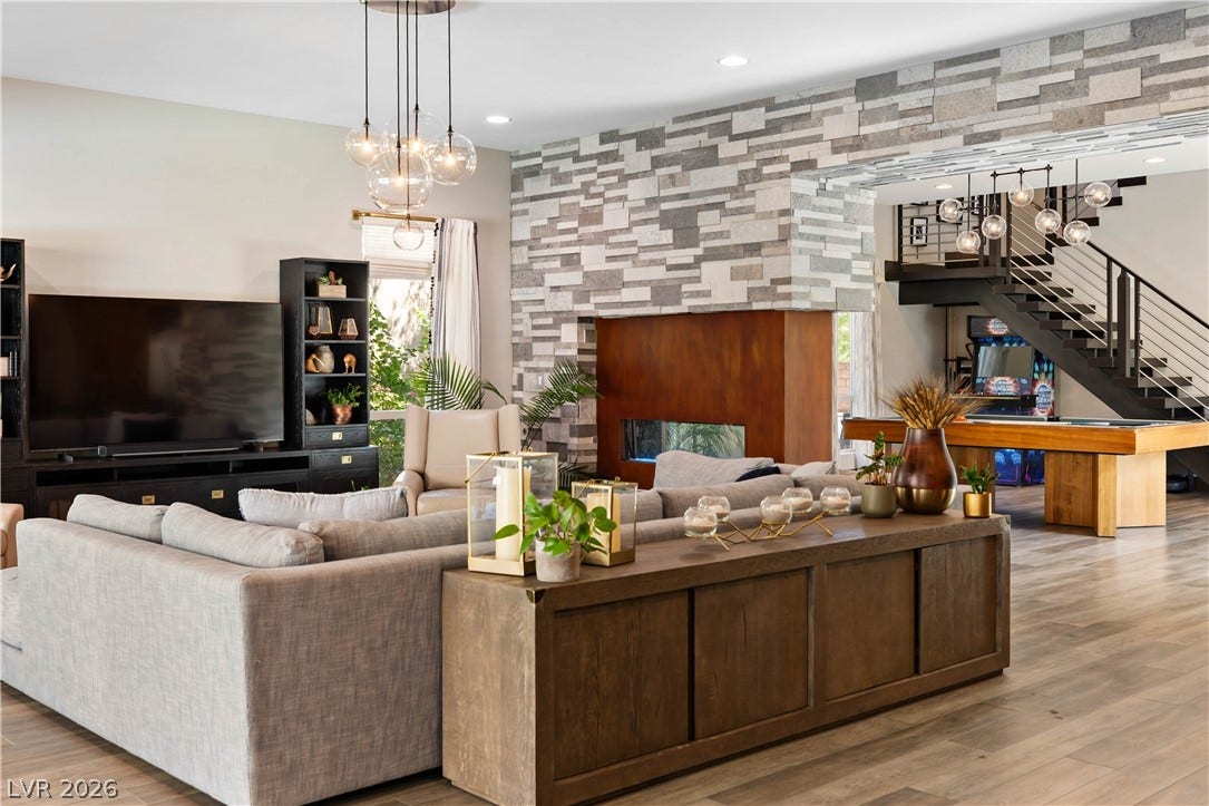 2999 The Peaks Lane, Las Vegas, NV 89138 An open floorplan connects the living spaces anchored by a modern stone fireplace.