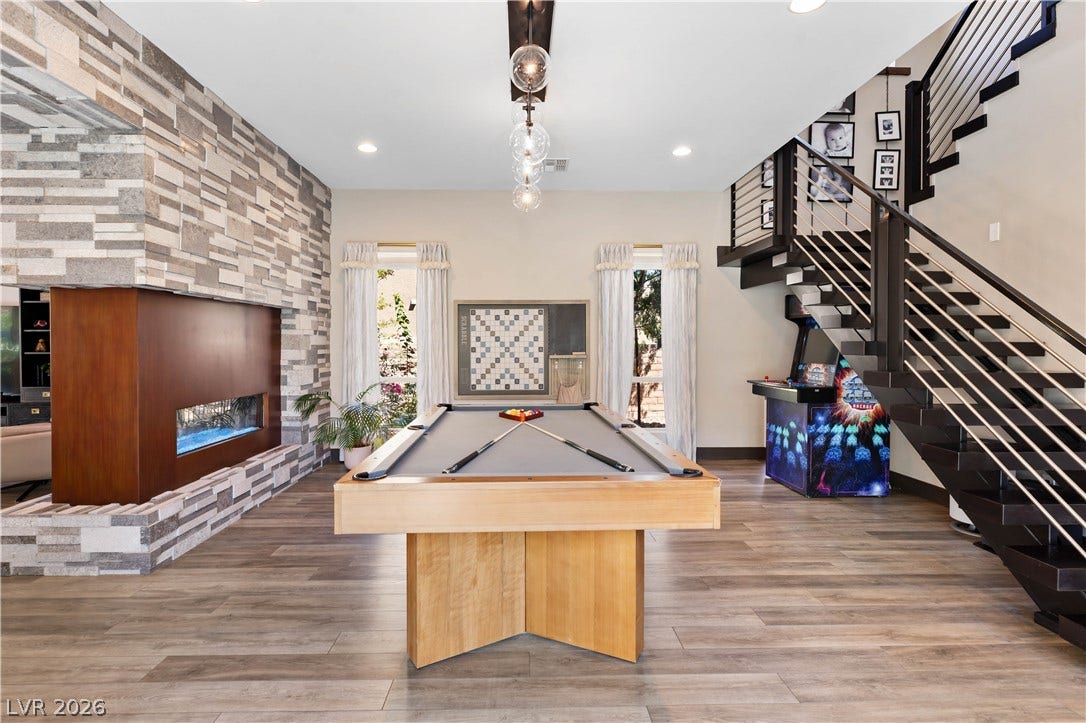 2999 The Peaks Lane, Las Vegas, NV 89138 2-way stone fireplace and floating staircase anchor this spacious flex space/ game room.
