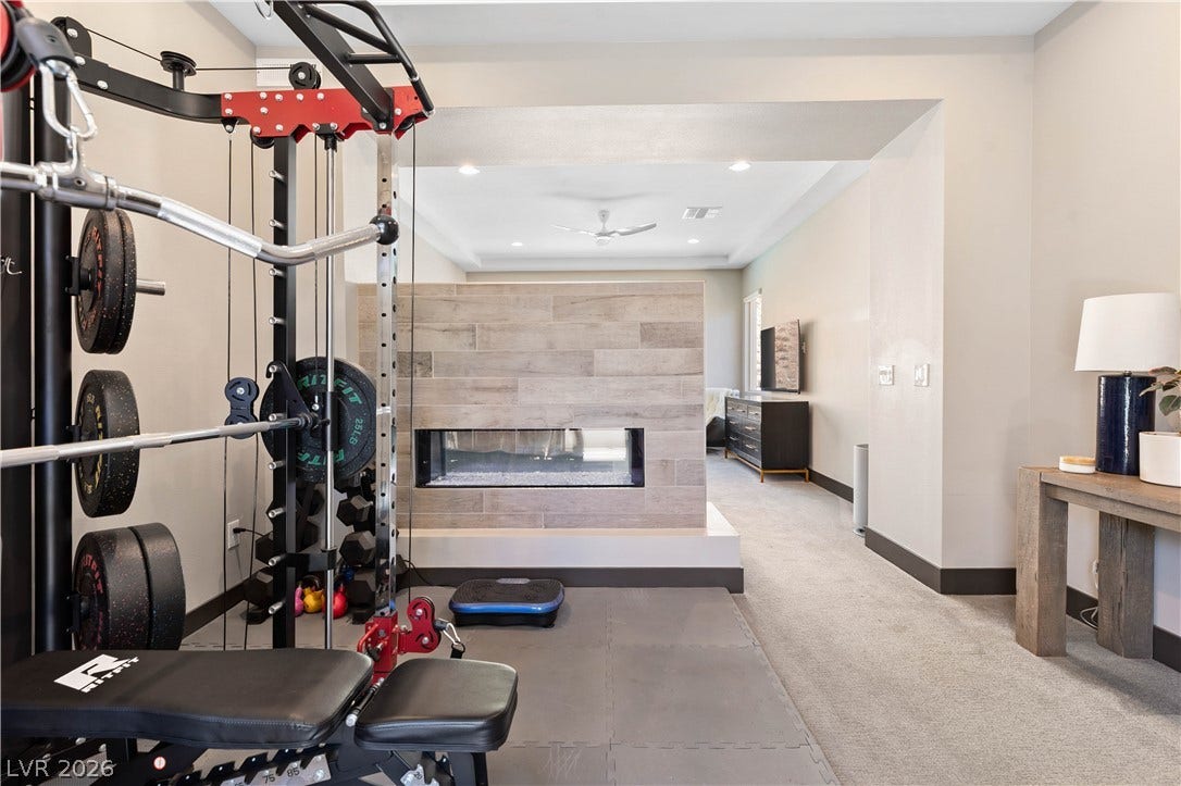 2999 The Peaks Lane, Las Vegas, NV 89138 Bonus room off primary suite with dual-sided fireplace.
Upstairs Primary bedroom (5)with large sitting area/gym separated by beautiful double sided fireplace. Huge Custom walk-in closet and highly upgraded primary bathroom and private balcony.