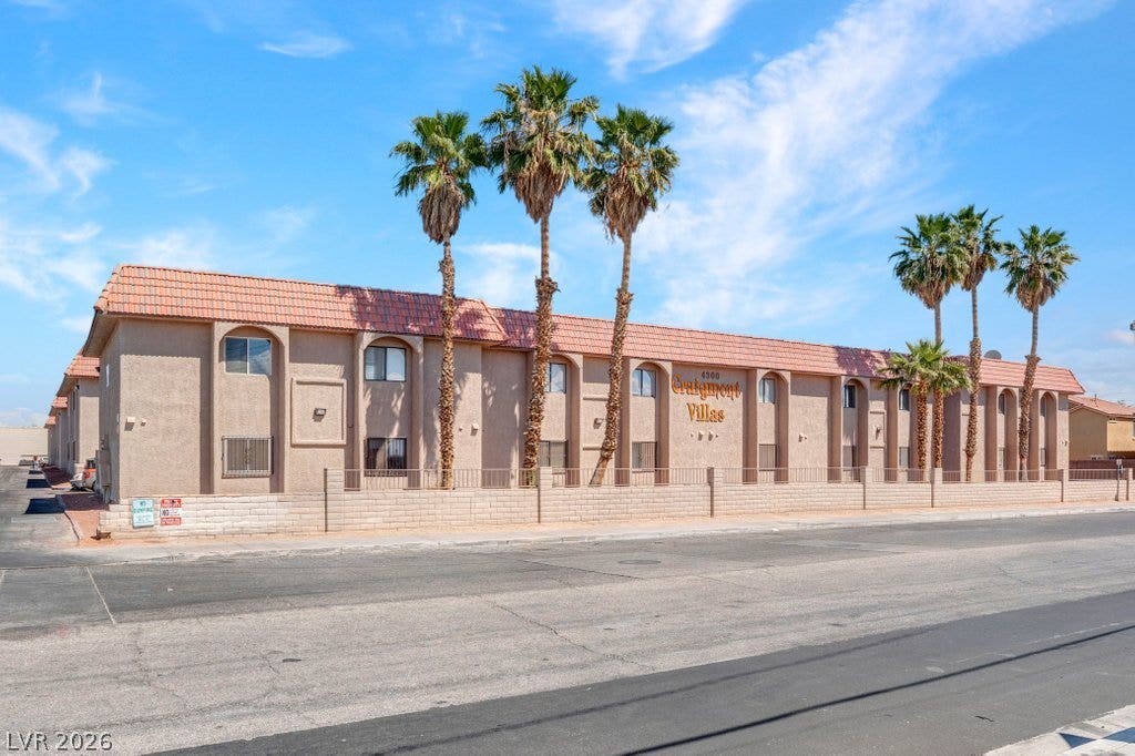 4300 N Lamont Street, #291, Las Vegas, NV 89115 Palm trees frame this multi-unit residential building under a bright blue sky.