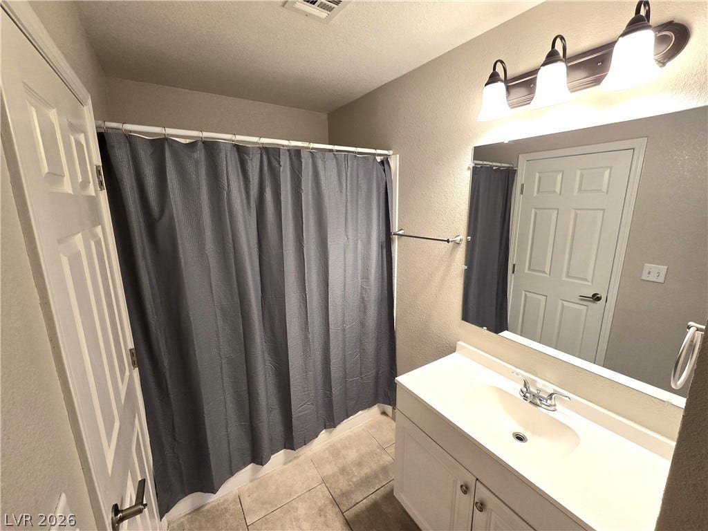 4300 N Lamont Street, #291, Las Vegas, NV 89115 A classic vanity mirror and clean tiled flooring define this inviting bathroom space.