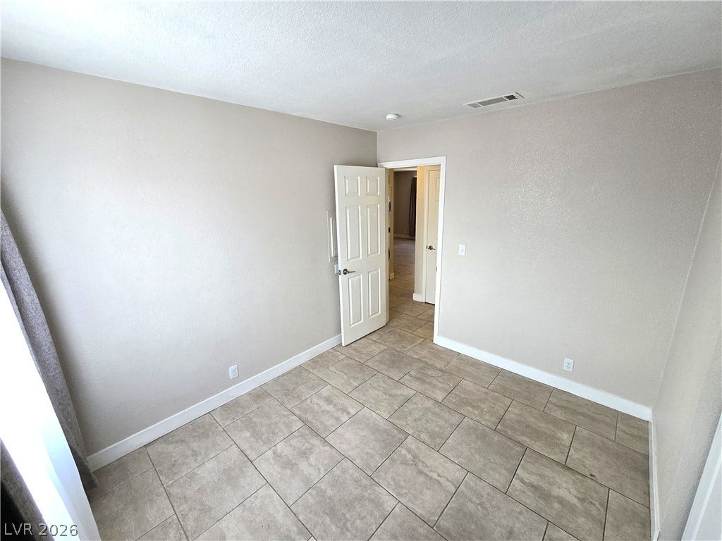 4300 N Lamont Street, #291, Las Vegas, NV 89115 Tiled flooring and simple neutral walls define this versatile secondary bedroom space.