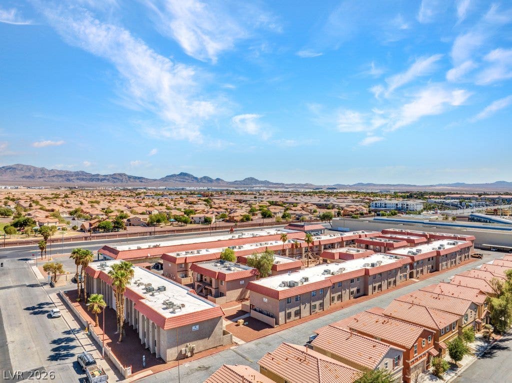 4300 N Lamont Street, #291, Las Vegas, NV 89115 Sun-drenched residential buildings stretch across a desert landscape set against distant mountain ranges.