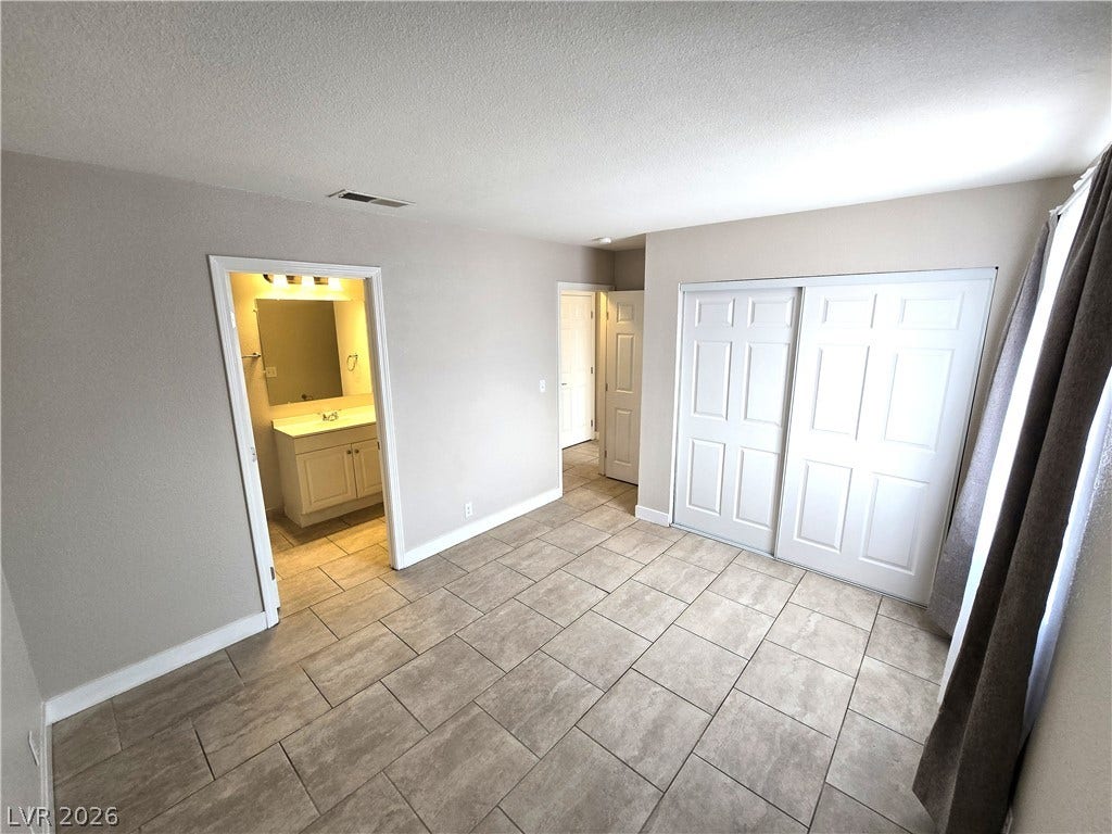 4300 N Lamont Street, #291, Las Vegas, NV 89115 Tiled flooring and closet doors define this practical living space leading into an adjacent bath.