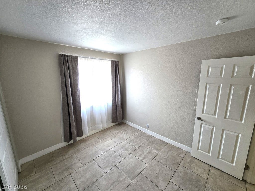 4300 N Lamont Street, #291, Las Vegas, NV 89115 Tiled flooring and a bright window define this versatile secondary bedroom space.