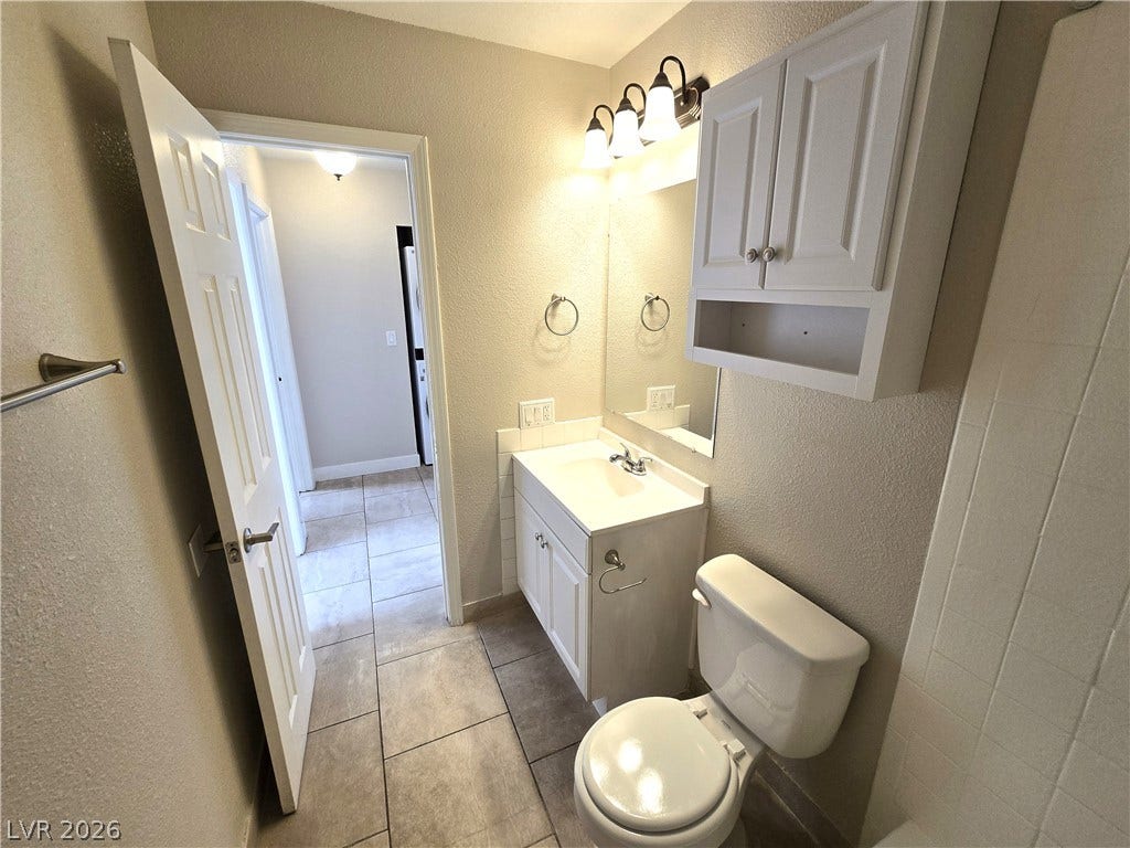 4300 N Lamont Street, #291, Las Vegas, NV 89115 A classic tiled floor complements the functional vanity and overhead cabinet in this cozy bathroom.