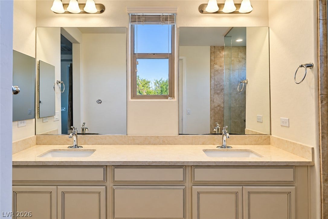 11886 Corenzio Avenue, Las Vegas, NV 89138 Double undermount sinks pair seamlessly with stone counters and dual mirrors in this washroom.