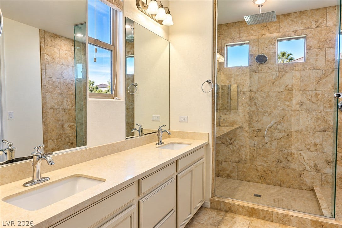 11886 Corenzio Avenue, Las Vegas, NV 89138 A stone-tiled walk-in shower anchors this dual-vanity bathroom with neutral finishes. Master Bathroom.