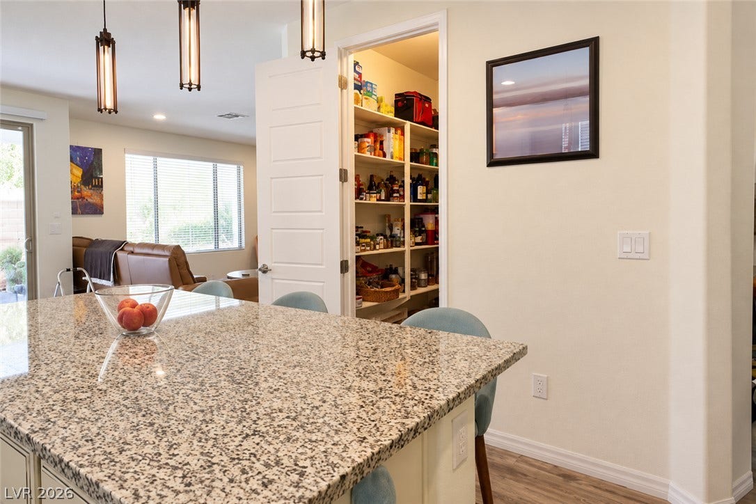 11886 Corenzio Avenue, Las Vegas, NV 89138 Granite countertops and an adjacent walk-in pantry highlight this functional kitchen workspace.