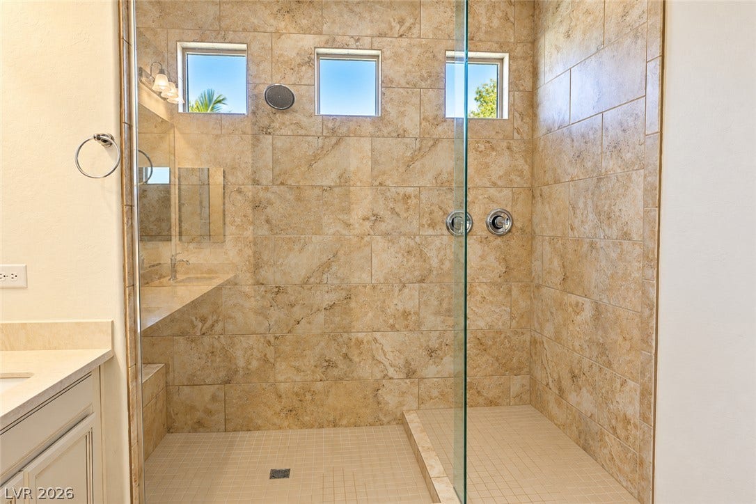 11886 Corenzio Avenue, Las Vegas, NV 89138 A spacious walk-in shower features floor-to-ceiling tile surrounds and glass paneling.