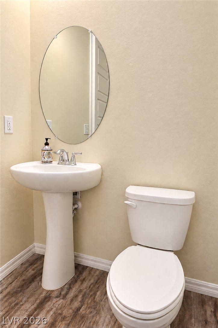 11886 Corenzio Avenue, Las Vegas, NV 89138 Clean and inviting bathroom featuring a pedestal sink, oval mirror, and warm neutral finishes.