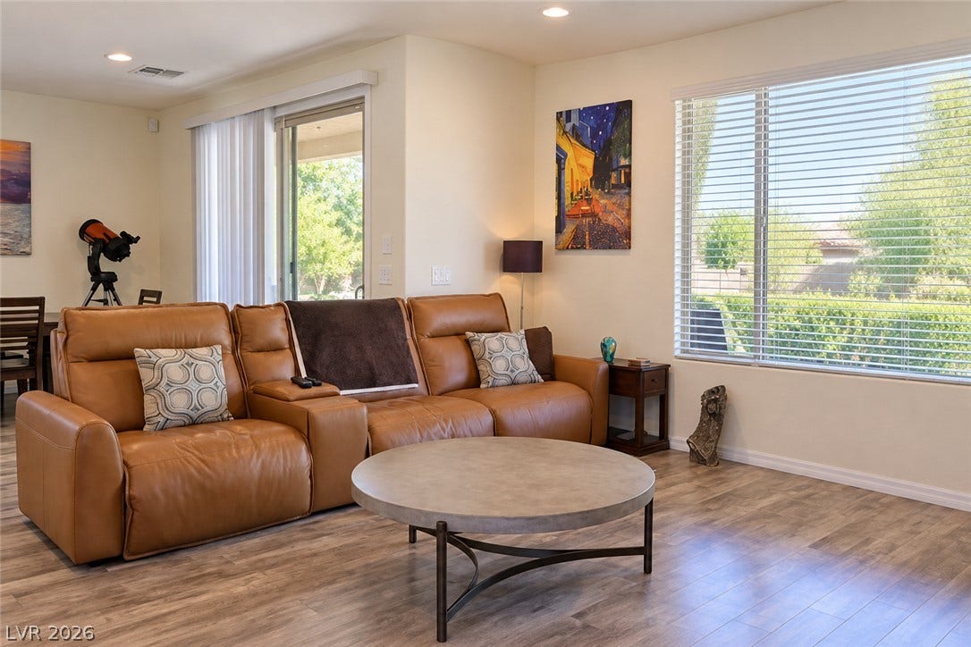 11886 Corenzio Avenue, Las Vegas, NV 89138 Warm wood flooring and recessed lighting define this inviting living area with large windows.