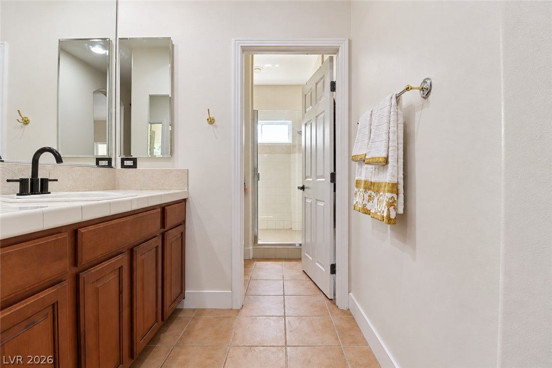 10 Caminito Amore, Henderson, NV 89011 Rich wood cabinetry and clean tile floors guide the eye toward the private shower room.