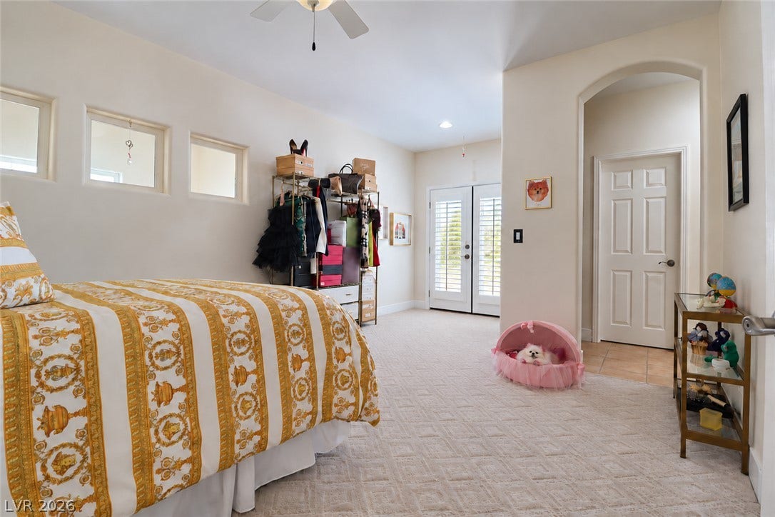 10 Caminito Amore, Henderson, NV 89011 Patterned carpeting and arched transitions define this spacious guest bedroom with patio-access doors.