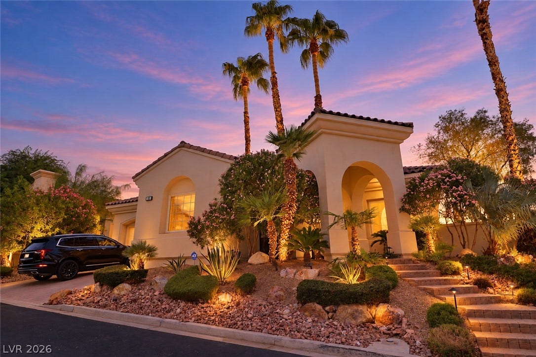 10 Caminito Amore, Henderson, NV 89011 Spanish-style architecture meets manicured desert landscaping under a vibrant twilight sky.