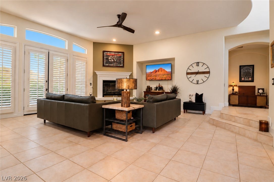 10 Caminito Amore, Henderson, NV 89011 An inviting hearth highlights the open-concept living space with tile flooring and tall windows.