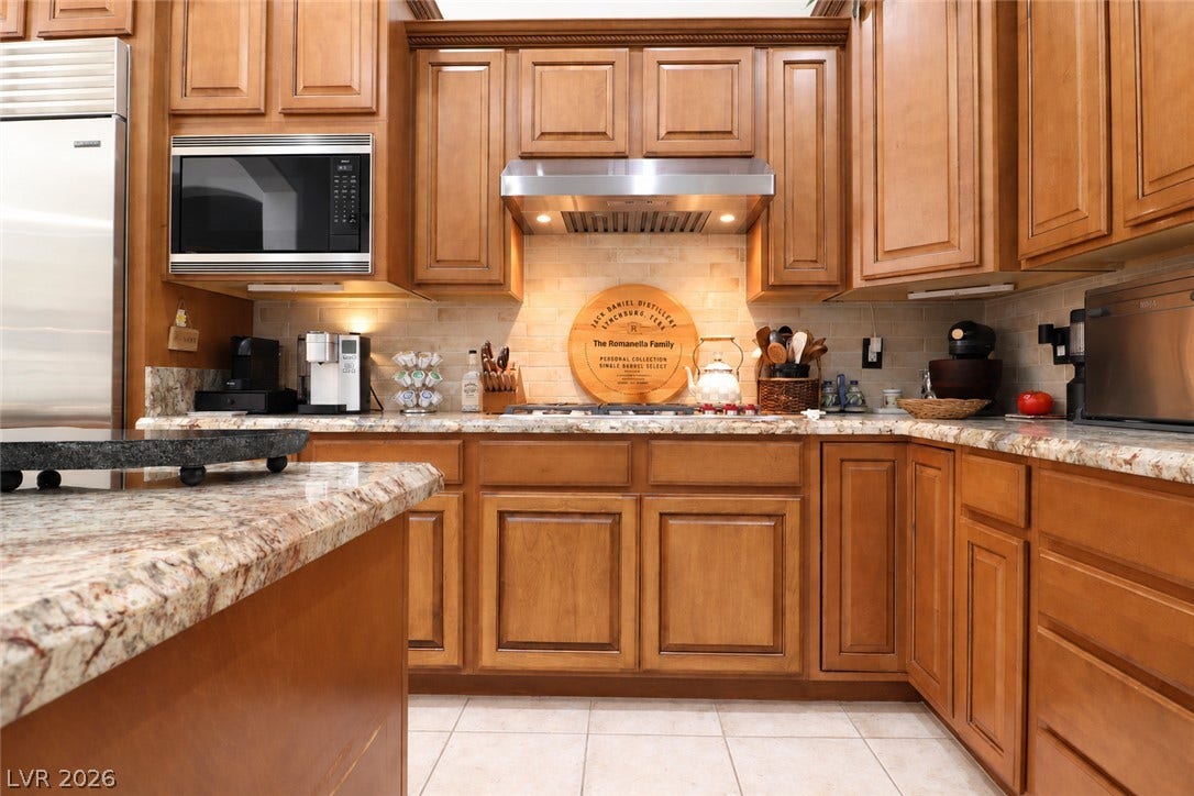 10 Caminito Amore, Henderson, NV 89011 Rich wood cabinetry surrounds premium built-in appliances and polished stone counters.