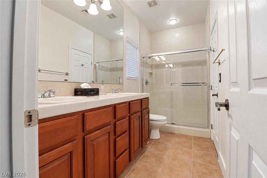 10 Caminito Amore, Henderson, NV 89011 Tiled flooring and a double vanity define this functional bathroom space.