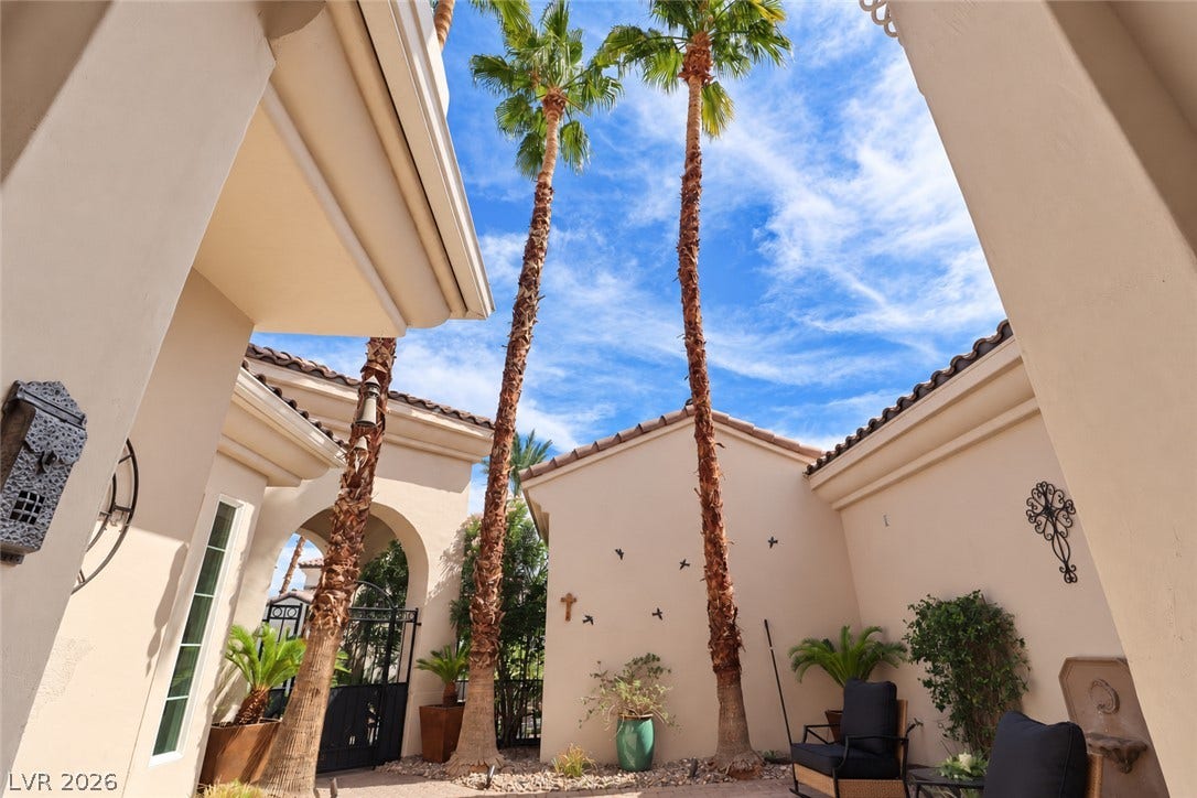 10 Caminito Amore, Henderson, NV 89011 Towering palm trees frame the open-air courtyard entryway of this Spanish-style residence.