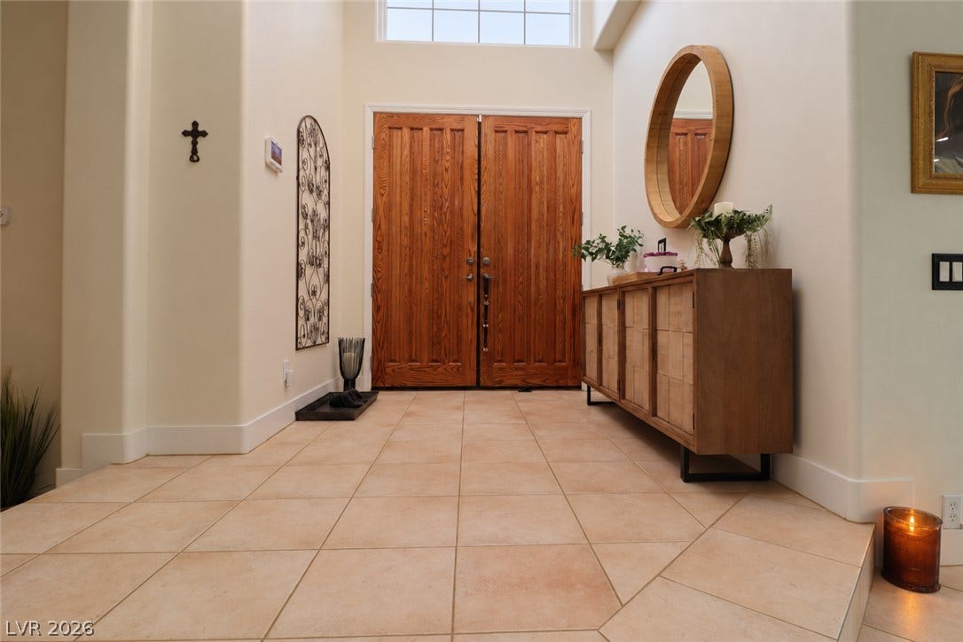 10 Caminito Amore, Henderson, NV 89011 Double entry doors open to a tiled foyer featuring high ceilings and clerestory lighting.