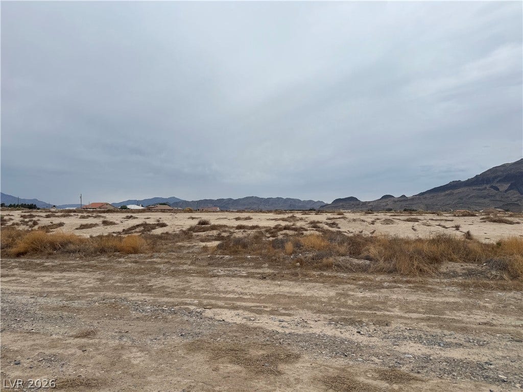 5560 N Linda Street, Pahrump, NV 89060 A sweeping desert parcel frames distant mountain ranges under an overcast sky.