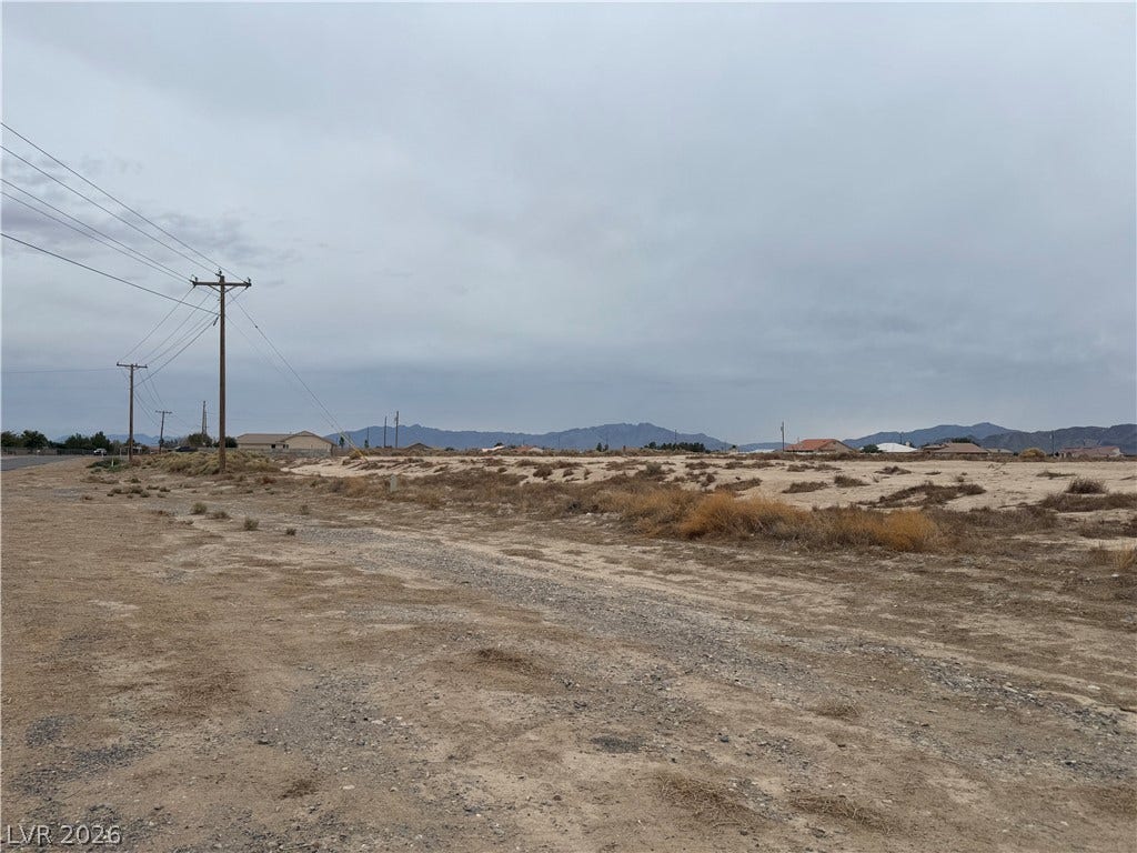 5560 N Linda Street, Pahrump, NV 89060 Distant mountain peaks frame this open desert lot under a dramatic sky.