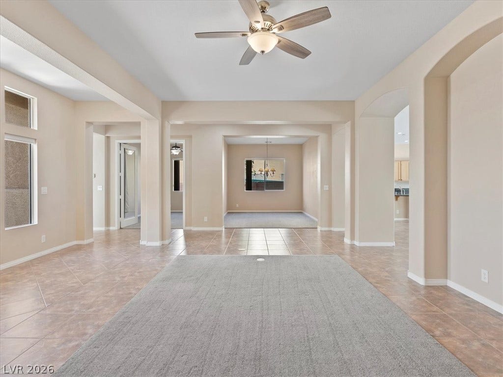 1217 Silent Sunset Avenue, North Las Vegas, NV 89084 Tiled walkways flank carpeted living spaces underneath smooth arched entries and high ceilings.