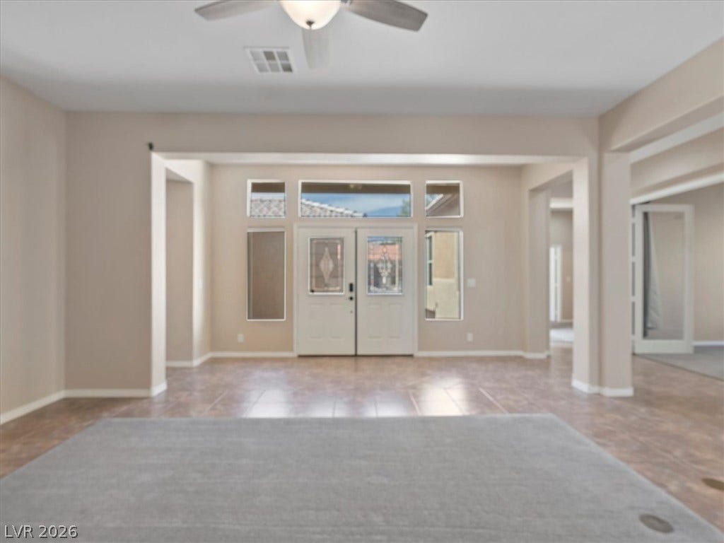 1217 Silent Sunset Avenue, North Las Vegas, NV 89084 Double entry doors with glass inserts welcome visitors into a versatile tile foyer.