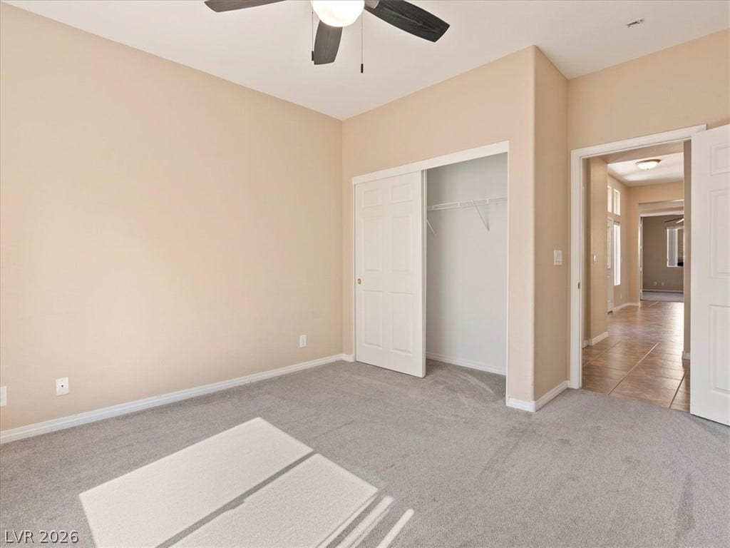 1217 Silent Sunset Avenue, North Las Vegas, NV 89084 Plush carpeting and a built-in closet define this versatile secondary bedroom space.