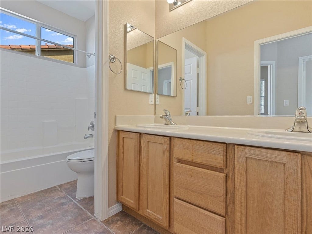 1217 Silent Sunset Avenue, North Las Vegas, NV 89084 Double vanities and classic wood cabinetry define this functional bathroom layout.