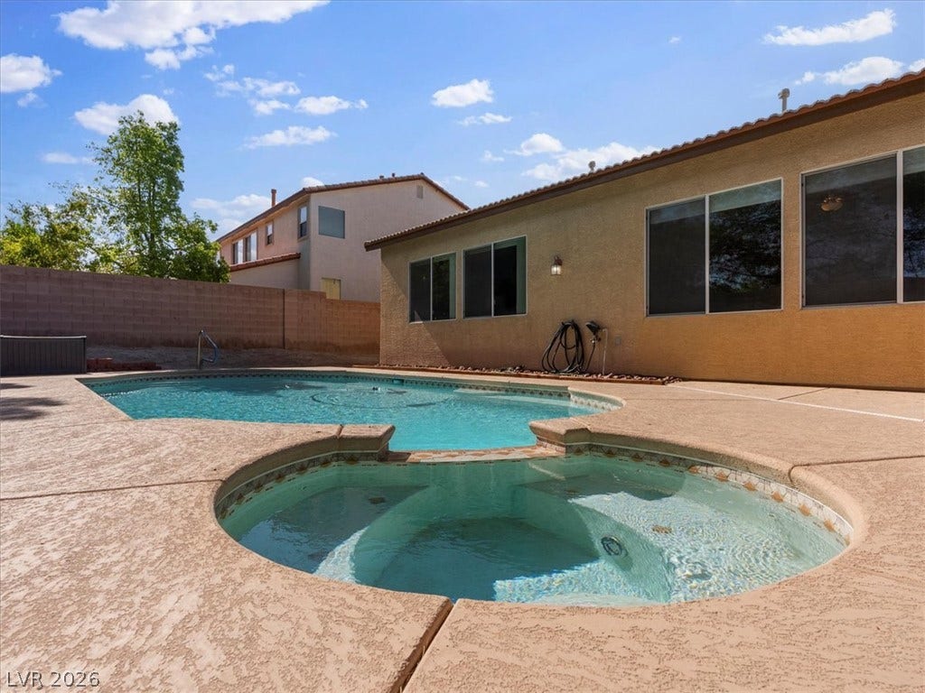 1217 Silent Sunset Avenue, North Las Vegas, NV 89084 An inviting backyard oasis features a shimmering swimming pool paired with a circular spa.