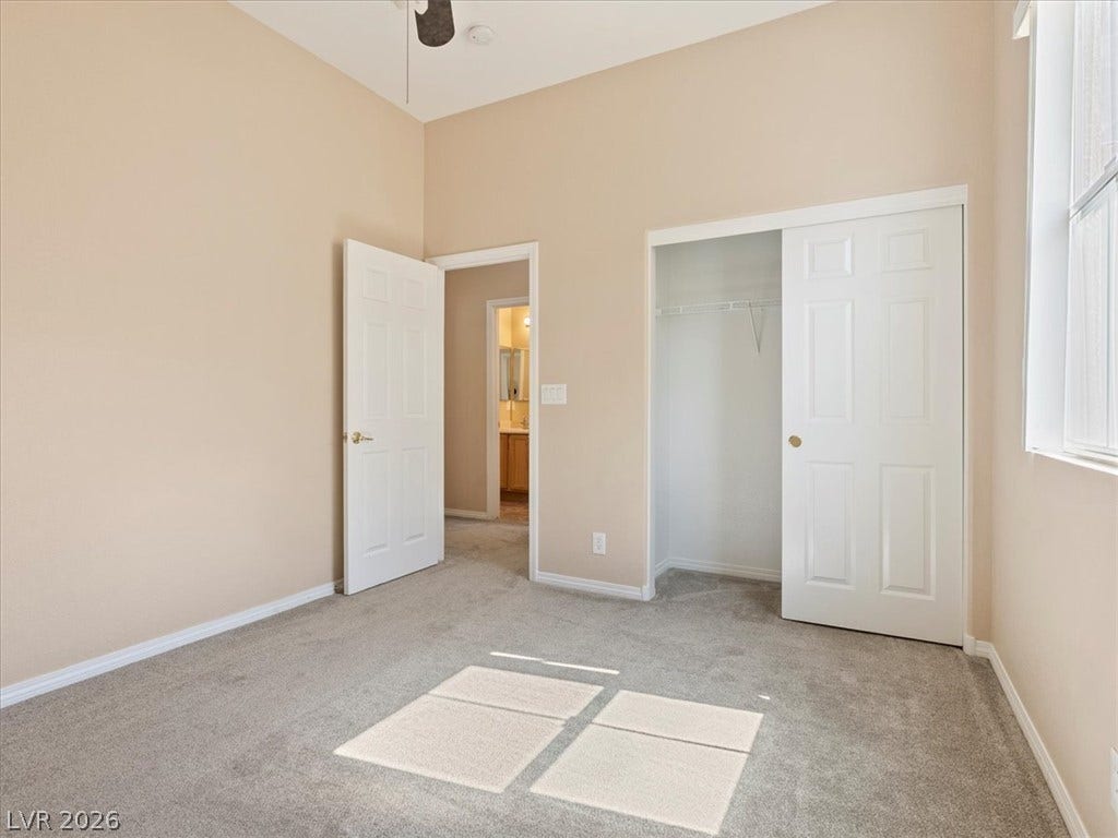 1217 Silent Sunset Avenue, North Las Vegas, NV 89084 A spacious bedroom offers plush neutral carpeting and a built-in closet with double doors.