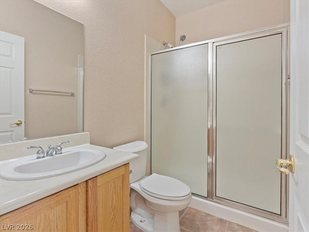 1217 Silent Sunset Avenue, North Las Vegas, NV 89084 A classic vanity and tiled floor define this functional bathroom space.