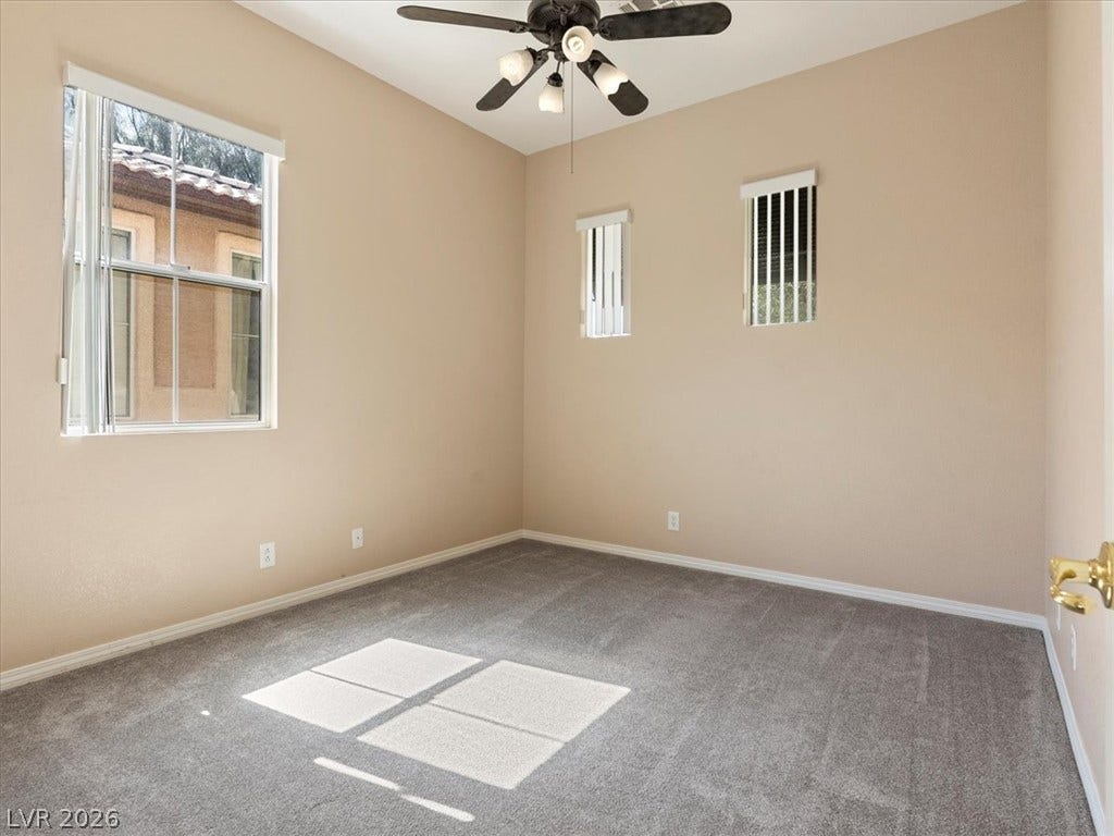 1217 Silent Sunset Avenue, North Las Vegas, NV 89084 Sunlight streams across carpeted flooring in this comfortable room featuring high ceilings and multiple windows.
