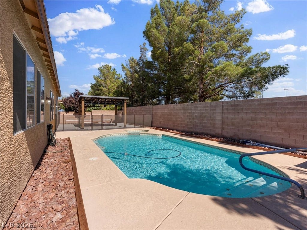 1217 Silent Sunset Avenue, North Las Vegas, NV 89084 A sparkling in-ground pool is bordered by a concrete patio and a privacy block wall.