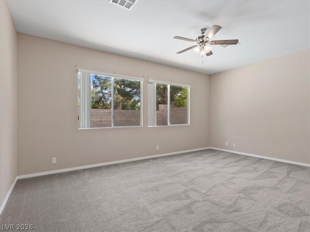 1217 Silent Sunset Avenue, North Las Vegas, NV 89084 Plush carpeting and dual windows frame views of the rear yard.