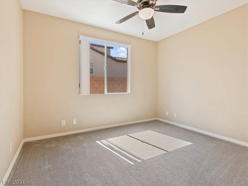 1217 Silent Sunset Avenue, North Las Vegas, NV 89084 Natural light streams across carpeted flooring in this comfortable bedroom space.